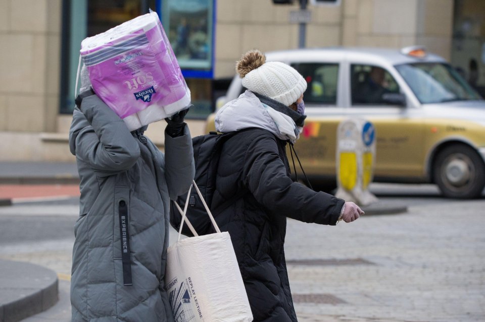  Shoppers carry a bumper pack of toilet paper home in Edinburgh