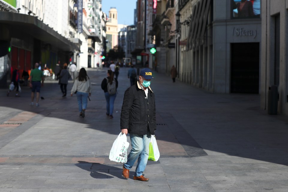  Man walks with his shopping bags through an almost empty Preciados street in Madrid