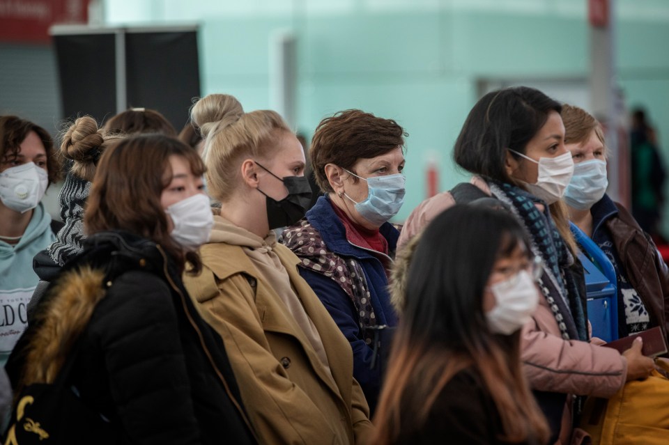  Passengers wearing masks line up as they wait to check in at Barcelona airport