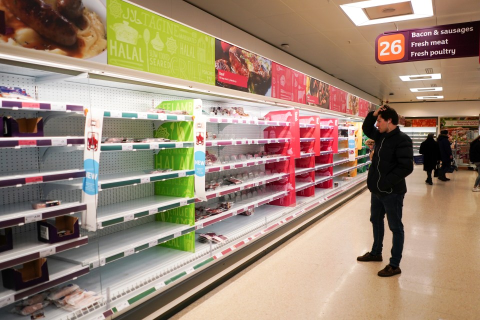  A man looks shocked at the lack of fresh meat on the shelves at a Sainsbury's in London