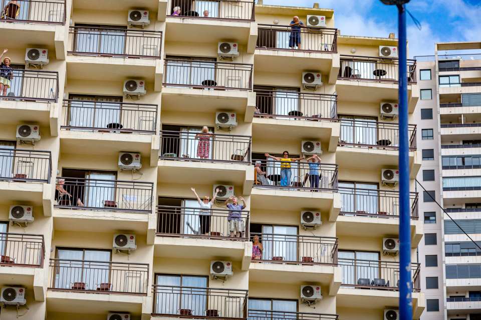 Stranded Brits wave from their hotel balconies in Benidorm