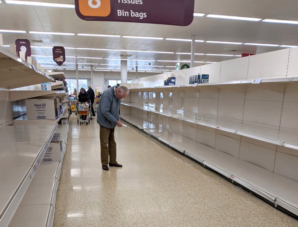 A photograph of an elderly man staring at empty shelves in a Sainsbury’s store in Epsom has gone viral