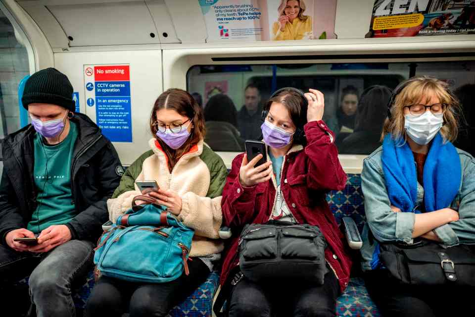  Members of the public sit on the Tube wearing face masks to protect themselves from coronavirus