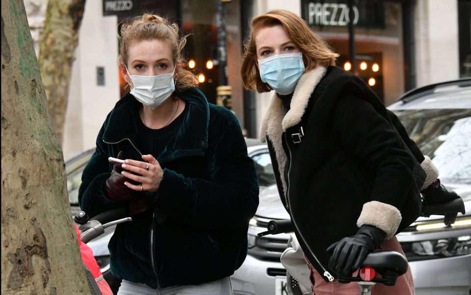  Two women wear face masks as emergency measures are expected to be announced