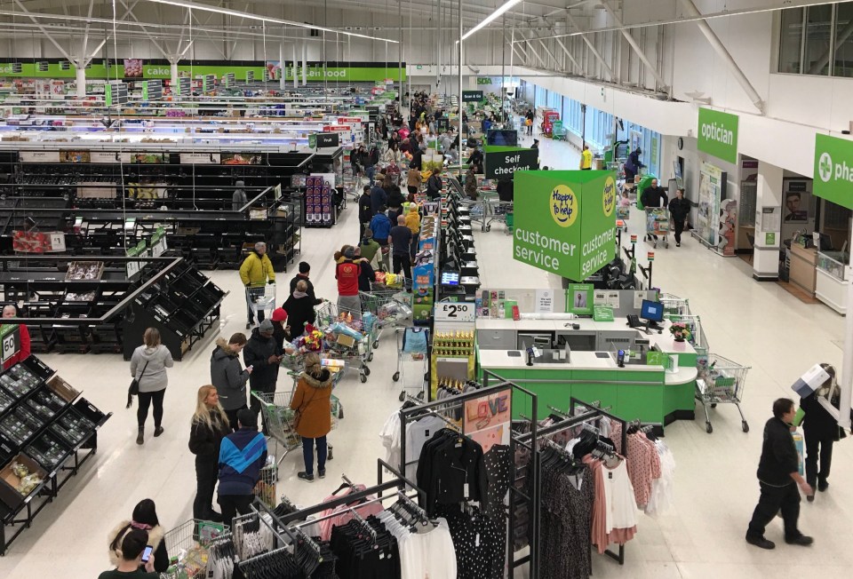 Customers queue to pay for their shopping in an ASDA supermarket in West Bridgford, Nottingham, at 7am