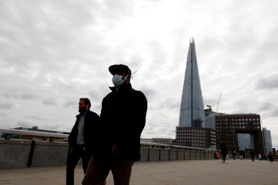  Two people walk through London in face masks as the capital is gripped by the spreading deadly bug