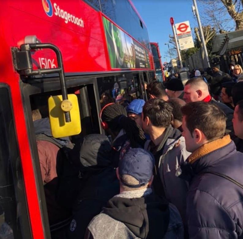  Londoners rush to board a packed bus