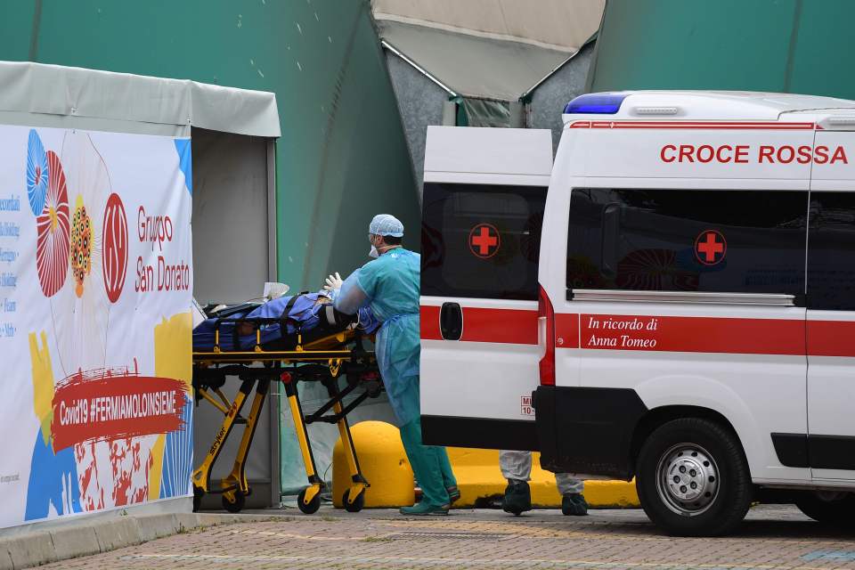  A medical worker stretches a patient from an Italian Red Cross ambulance into a intensice care unit