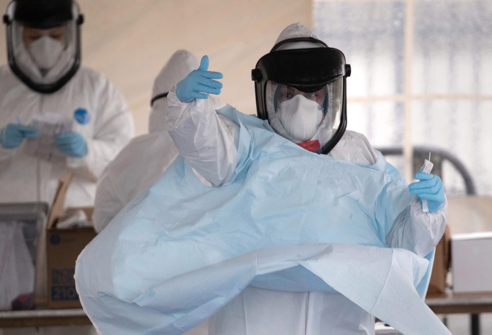  Medics gear up with personal protective equipment at a coronavirus testing station in Connecticut