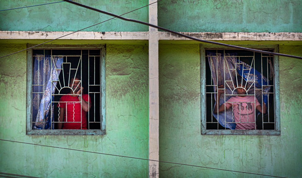 ndians look through the windows of a building during a lockdown to control coronavirus spread, in Gauhati,