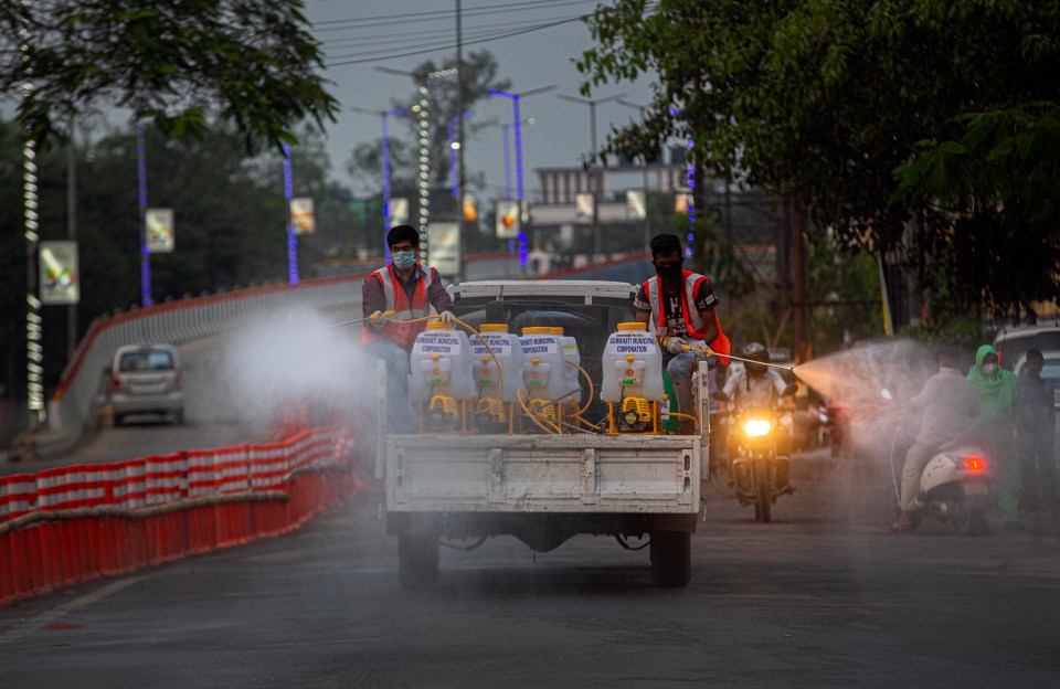 Indian firefighters spray disinfectants as a preventive measure against the spread of the new coronavirus on a street in Gauhat