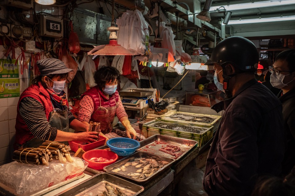  Residents wearing face masks buy seafood at a wet market on January 28, 2020 in Macau, China