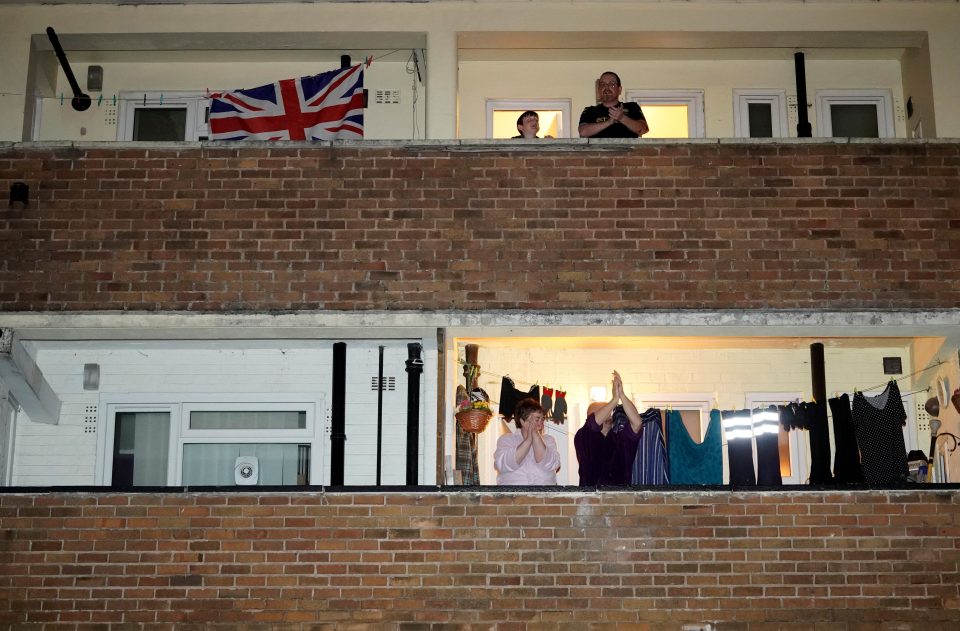  People applaud the NHS from their balconies and gardens across the road from Wythenshawe Hospital