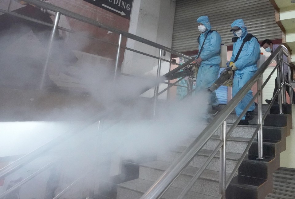 Staff members disinfect a shopping mall in Wuhan as China eases its lockdown