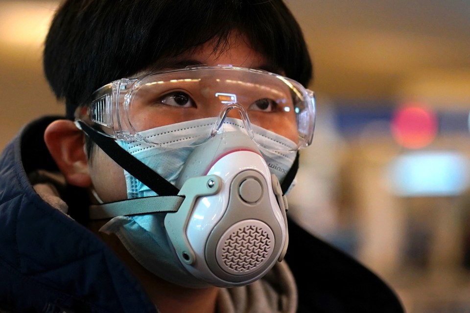  A passenger wearing a protective mask arrives at a railway station in Wuhan on the first day inbound train services resumed