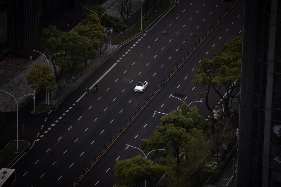 A lone car drives down an isolated highway in the outbreak epicentre