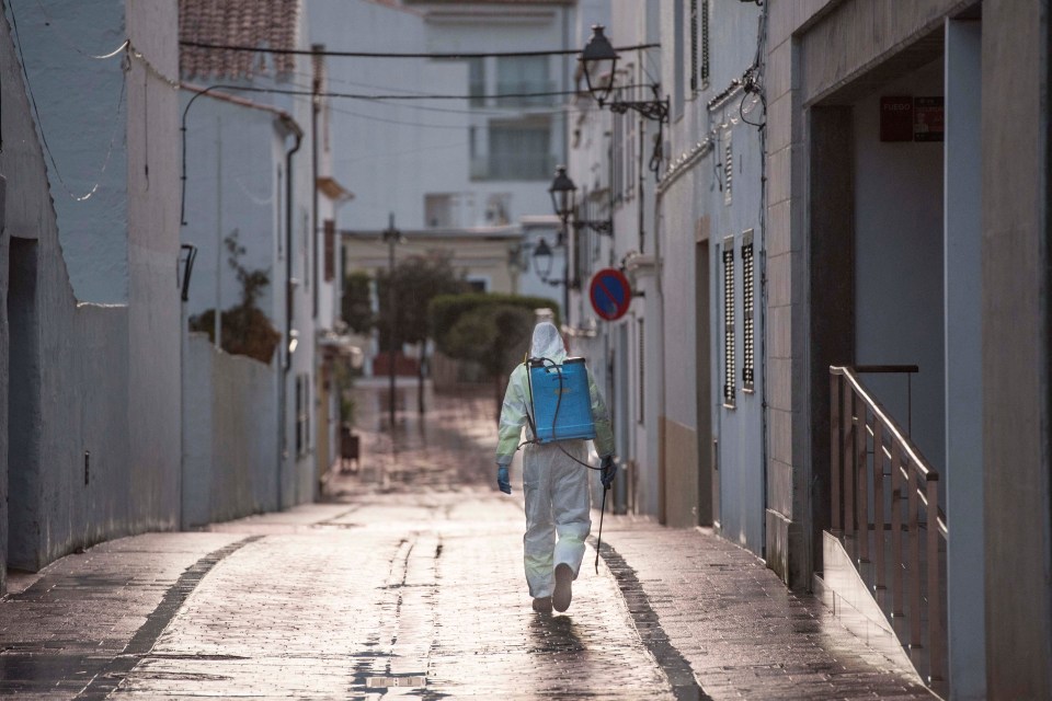 A member of Balearic cleaning team disinfects the streets of Mahon in Menorca