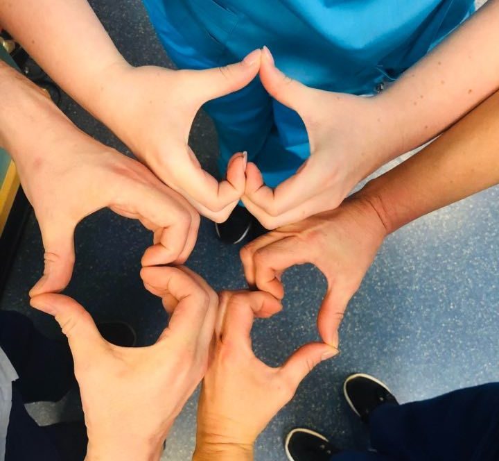 Ashleigh and her colleagues perform ‘love signs’ with their hands