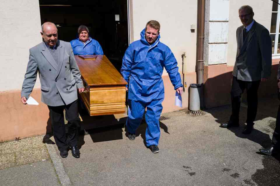  Funeral company workers in hazmat suits carry the coffin of a victim in Mulhouse, eastern France