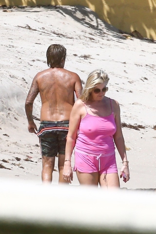  Penny went for a stroll on the beach as Rod's son Sean played on skimboards in the water