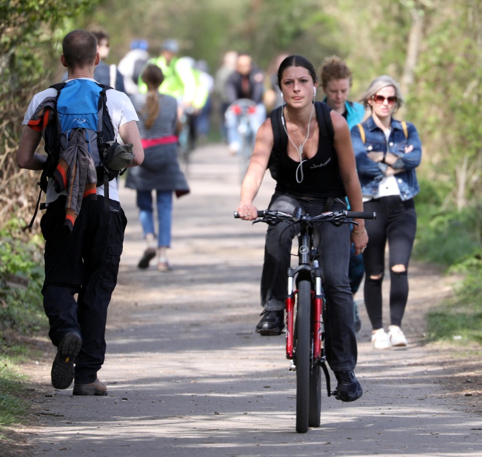 A woman rides her bike through busy Bristol