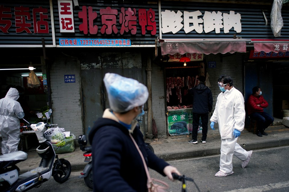  People wearing protective suits were seen at a street market in Wuhan