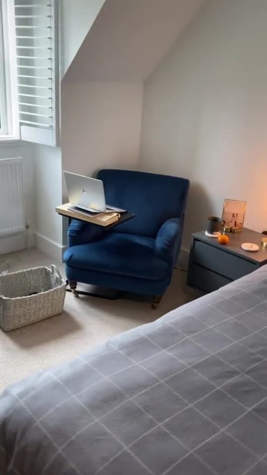  A dark blue armchair acts as a feature accessory in the corner