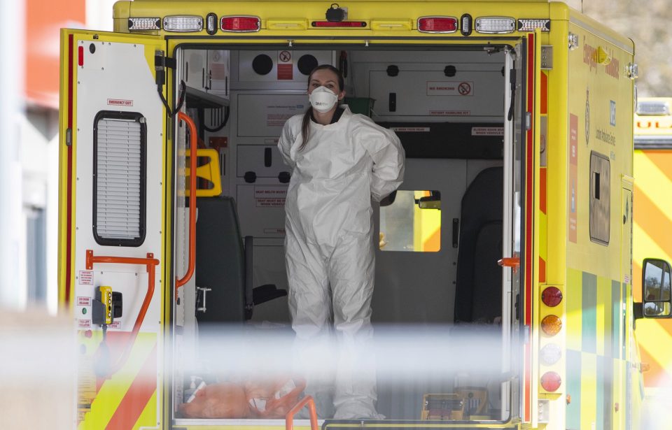  An NHS worker wearing PPE in the back of an ambulance outside a Nightingale hospital