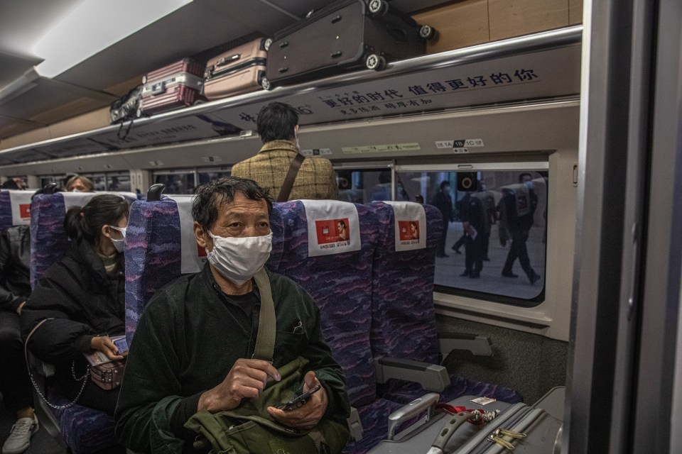  A man on board a train waiting to depart Wuhan