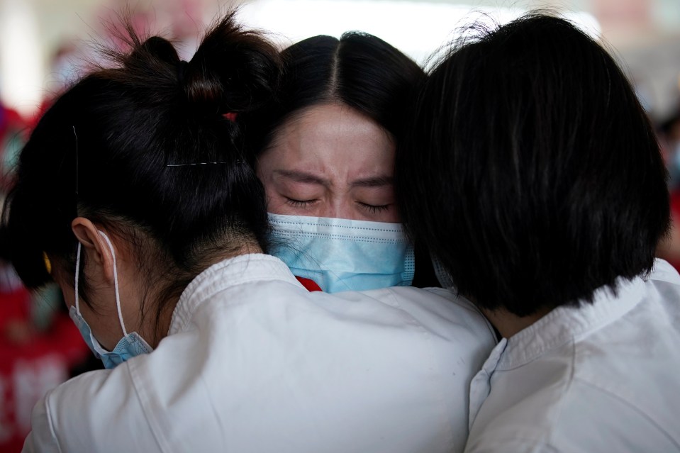  Medical workers hug each other at Wuhan airport before returning home