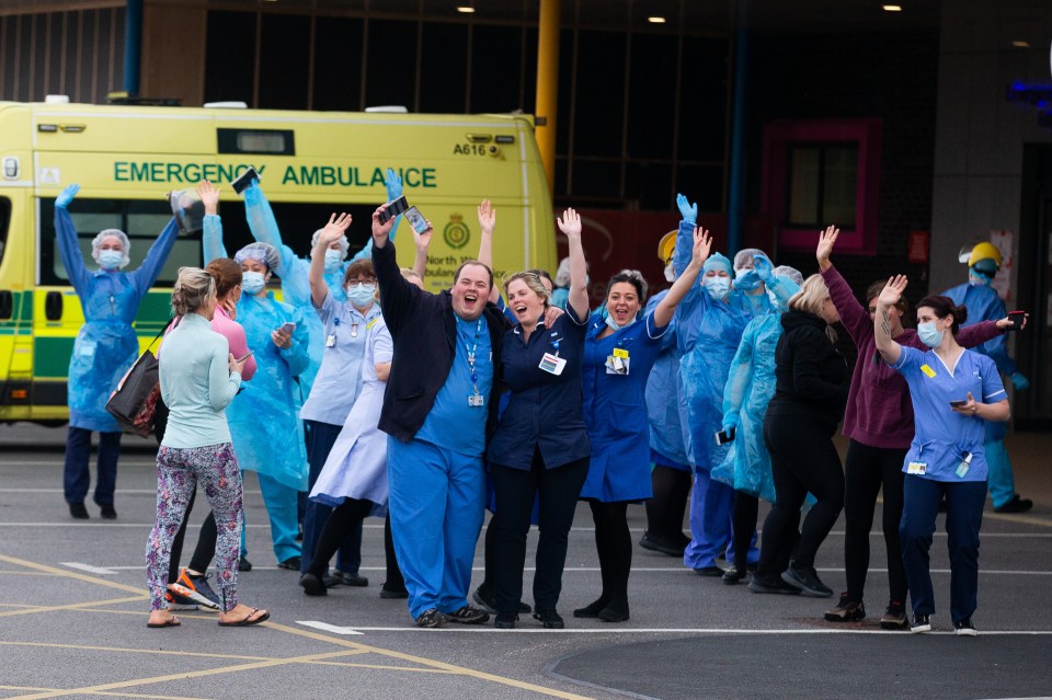  NHS cheer and wave for the camera after an aircraft showing an NHS tribute banner flew over Fazakerley Hospital in Liverpool