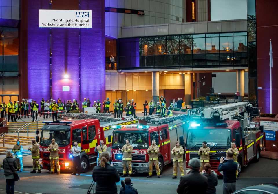  Members of the fire brigade, construction workers and members of the public, clapping outside the Nightingale Hospital at the Harrogate Convention Centre