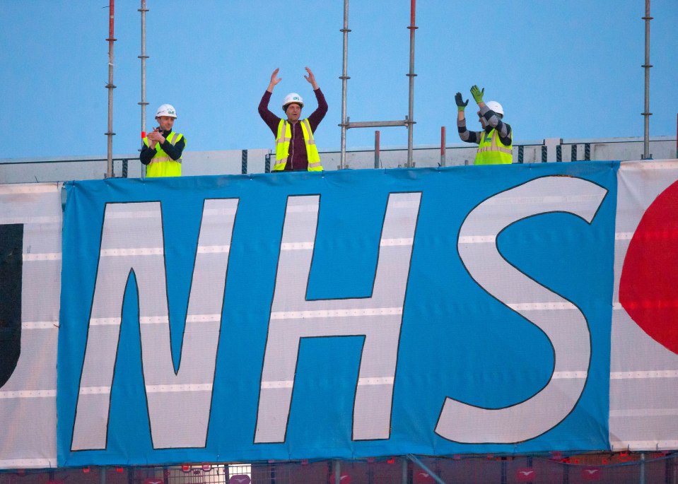  Builders on a site show their appreciation for the NHS