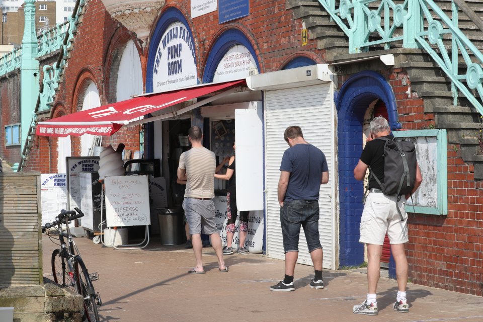  While the NHS prepares for yet more coronavirus deaths, Brits queue at a take away cafe on Brighton seafront