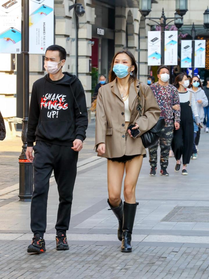  People wearing masks walk at a commercial pedestrian street in Wuhan following the lifting of the city's 76-day lockdown on April 12