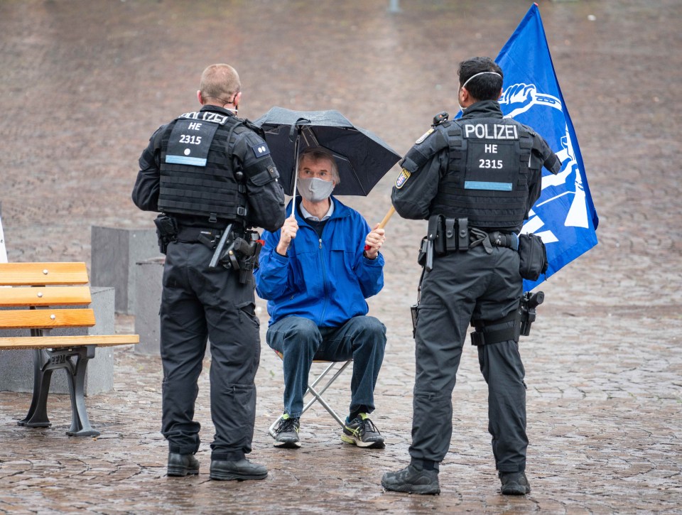 A peace activist is moved on by German police amid a nationwide lockdown to stop coronavirus