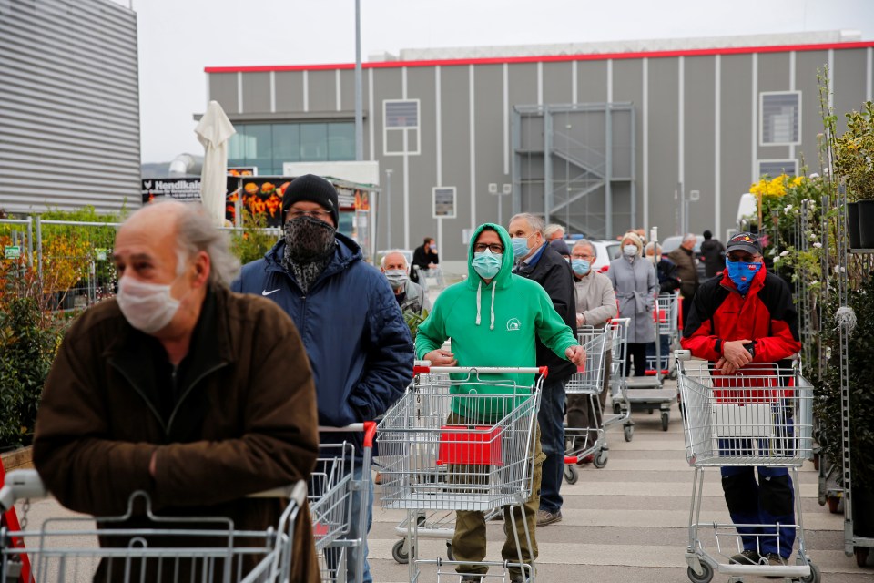 Shoppers queue to enter a DIY and garden superstore in Austria today after the government partially eased the lockdown