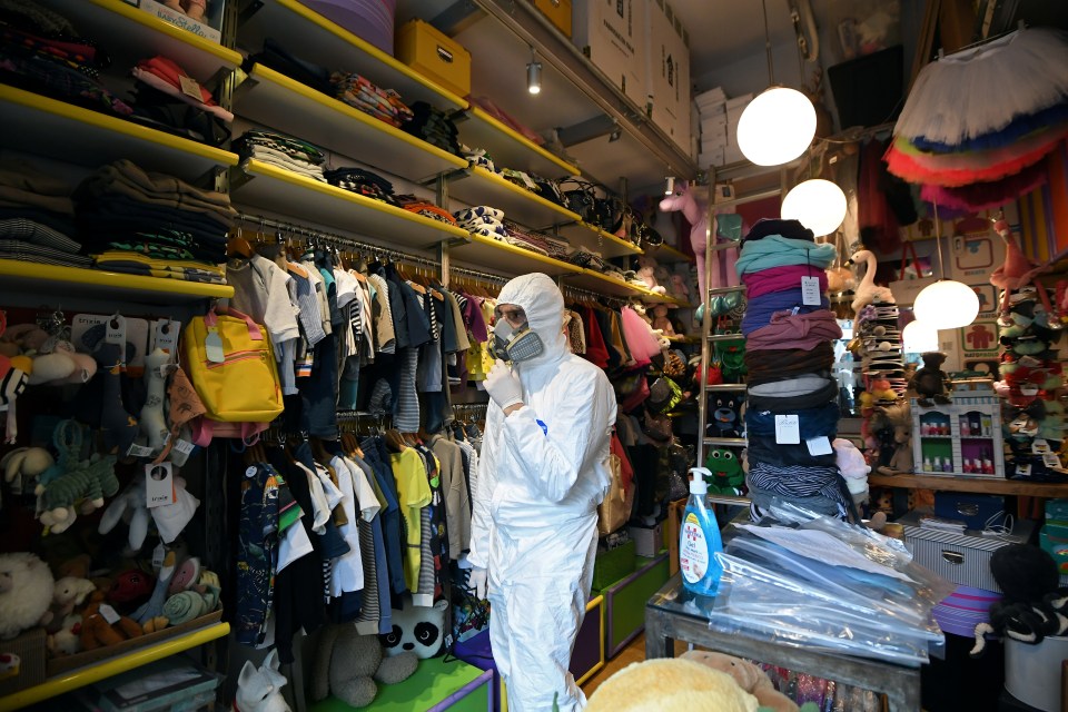 A government worker inspects a children's clothes shop before it reopened today in Trastevere, Rome