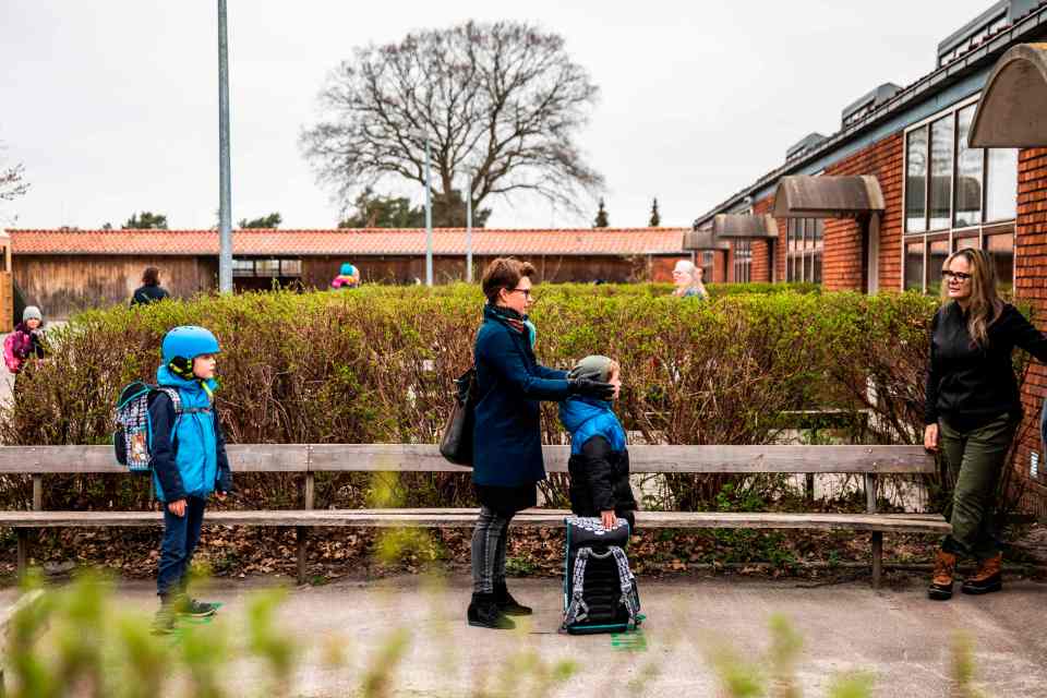 Parents and children line up in Copenhagen, Denmark as schools reopen