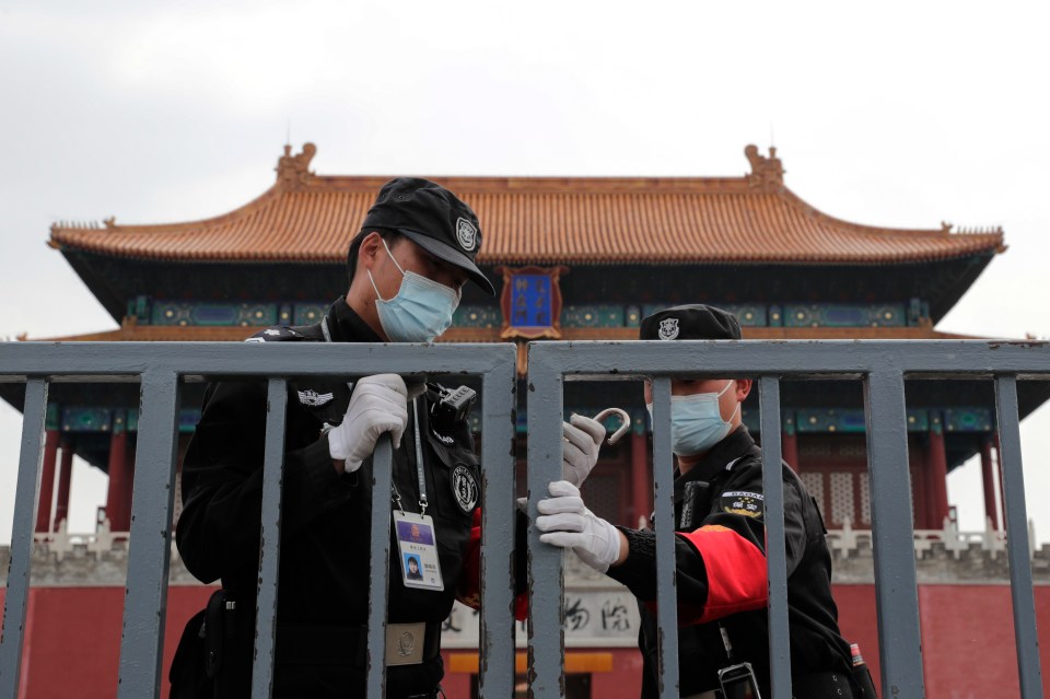  Security guards wearing protective face masks lock the gate of the Forbidden City which remains closed following the new coronavirus outbreak in Beijing