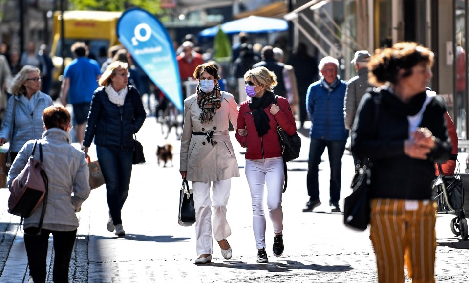 Shoppers walk arm-in-arm as they browse shops in Gelsenkirchen, Germany