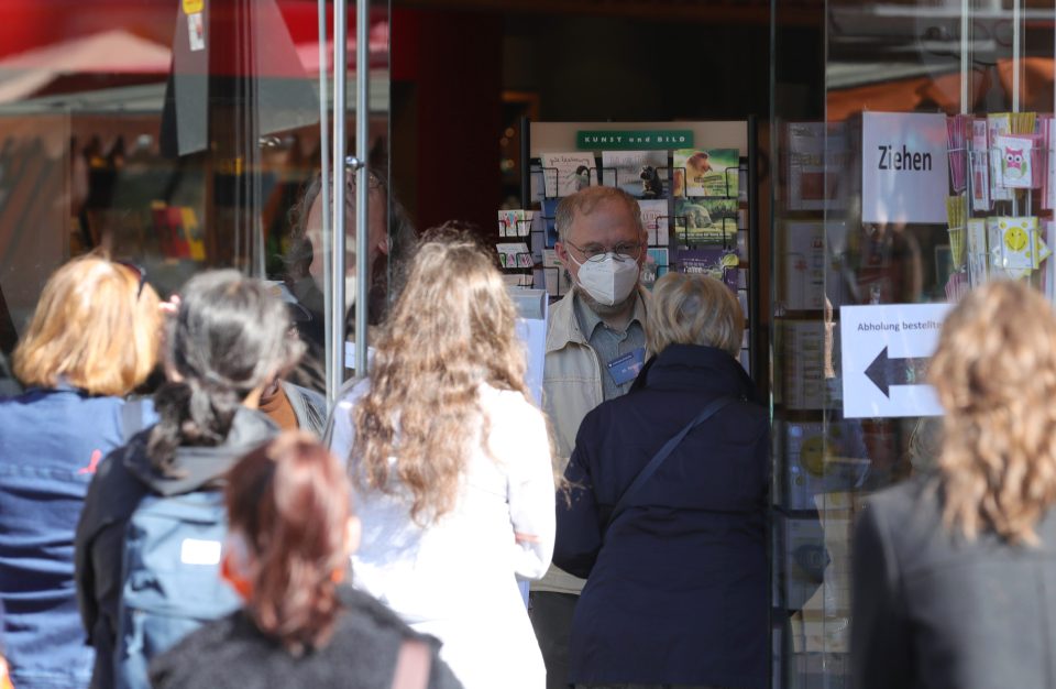 Customers queue for a reopened book shop in Bonn, Germany