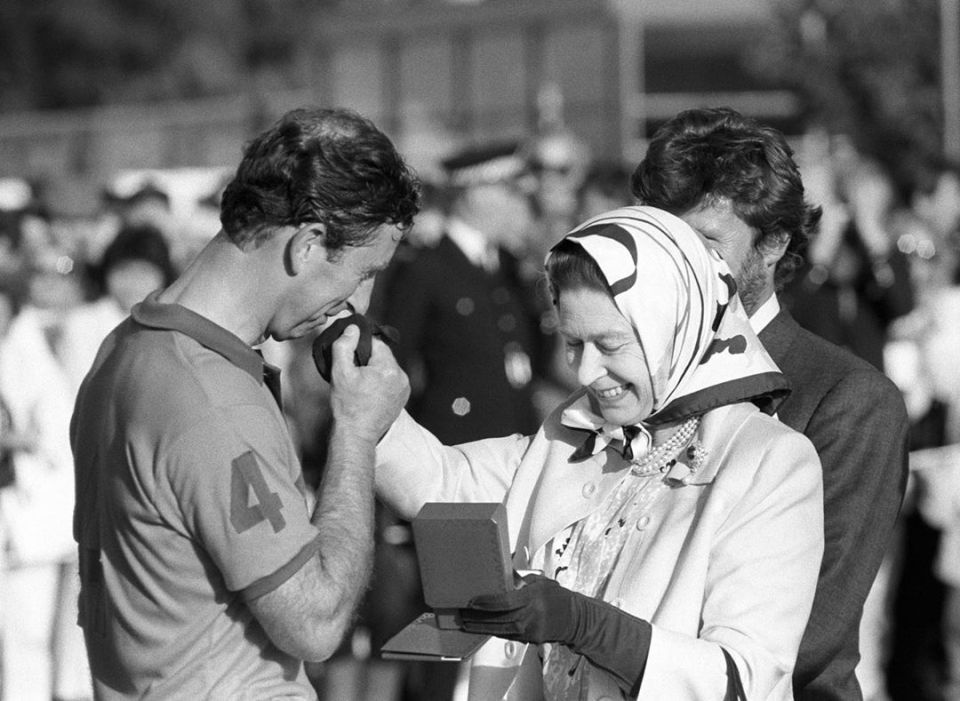  The Queen presents Prince Charles with a runners-up prize at the Silver Jubilee Cup match against France at Windsor Great Park, 1988.