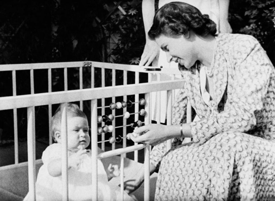  Queen Elizabeth II with her baby Prince Charles in the grounds of Windlesham Moor, country home in Surrey