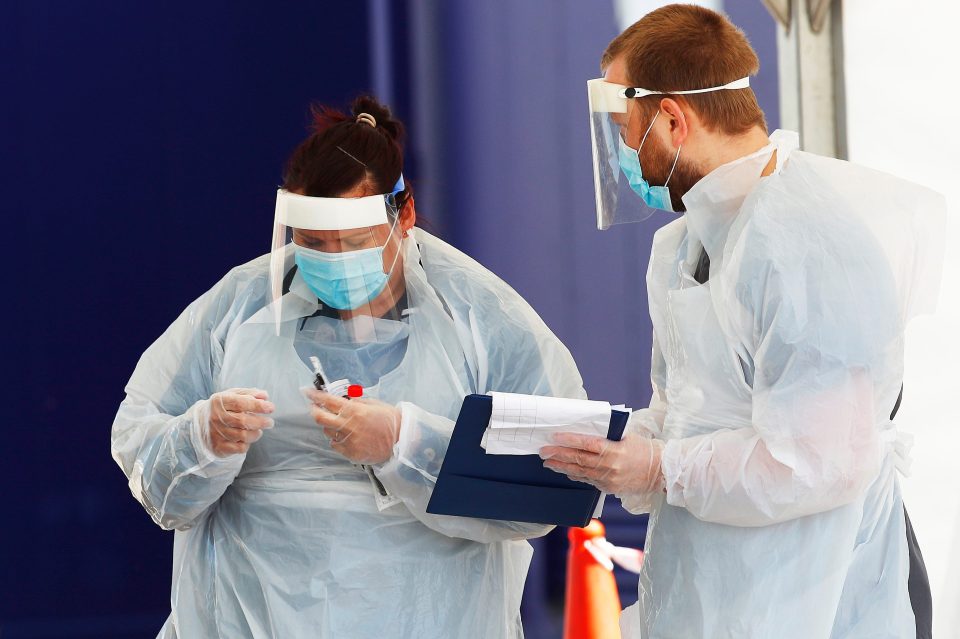  An NHS worker goes through the testing procedure at a centre for staff and registered care workers in Salford, Greater Manchester