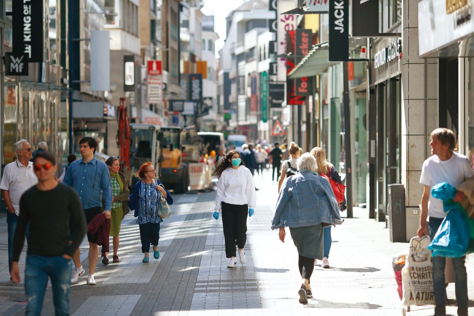 People stroll at the shopping district 'Hohe Strasse' in Cologne today