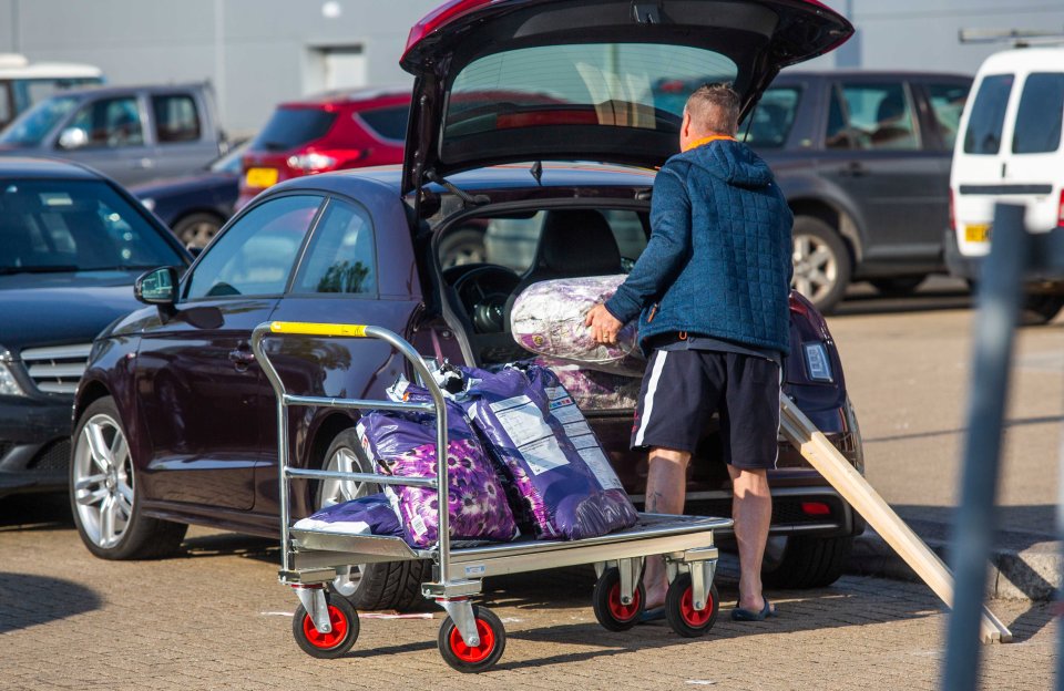  A man loads garden supplies into his car after hitting the DIY shop