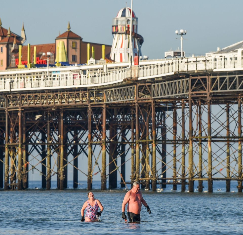  Early morning swimmers enjoy a dip in the sea by Brighton Palace Pier on a hot sunny day during the lockdown