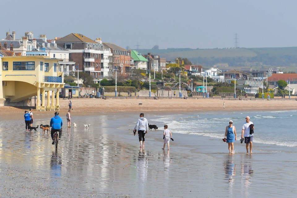 People exercise on the beach at Weymouth in Dorset during one of the hottest April days ever recorded