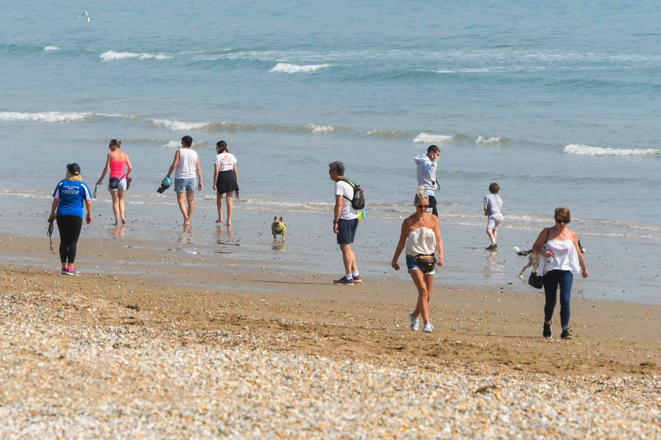  People walking along the beach at Lyme Regis yesterday